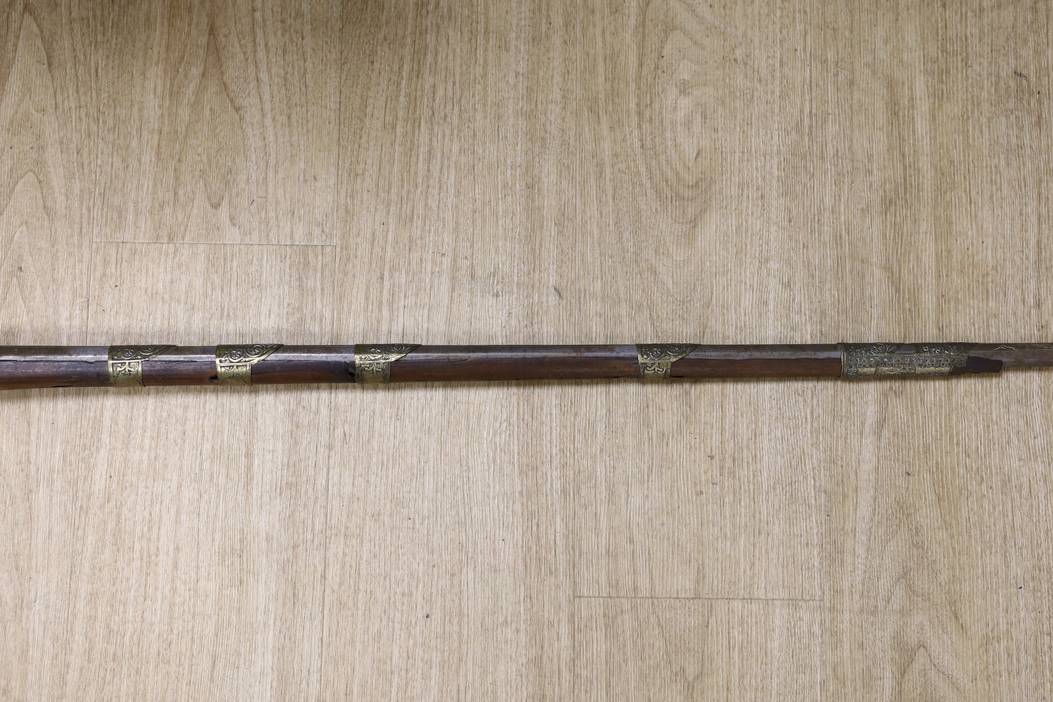 An Eastern decoratively metal mounted antique musket, 132cms long.